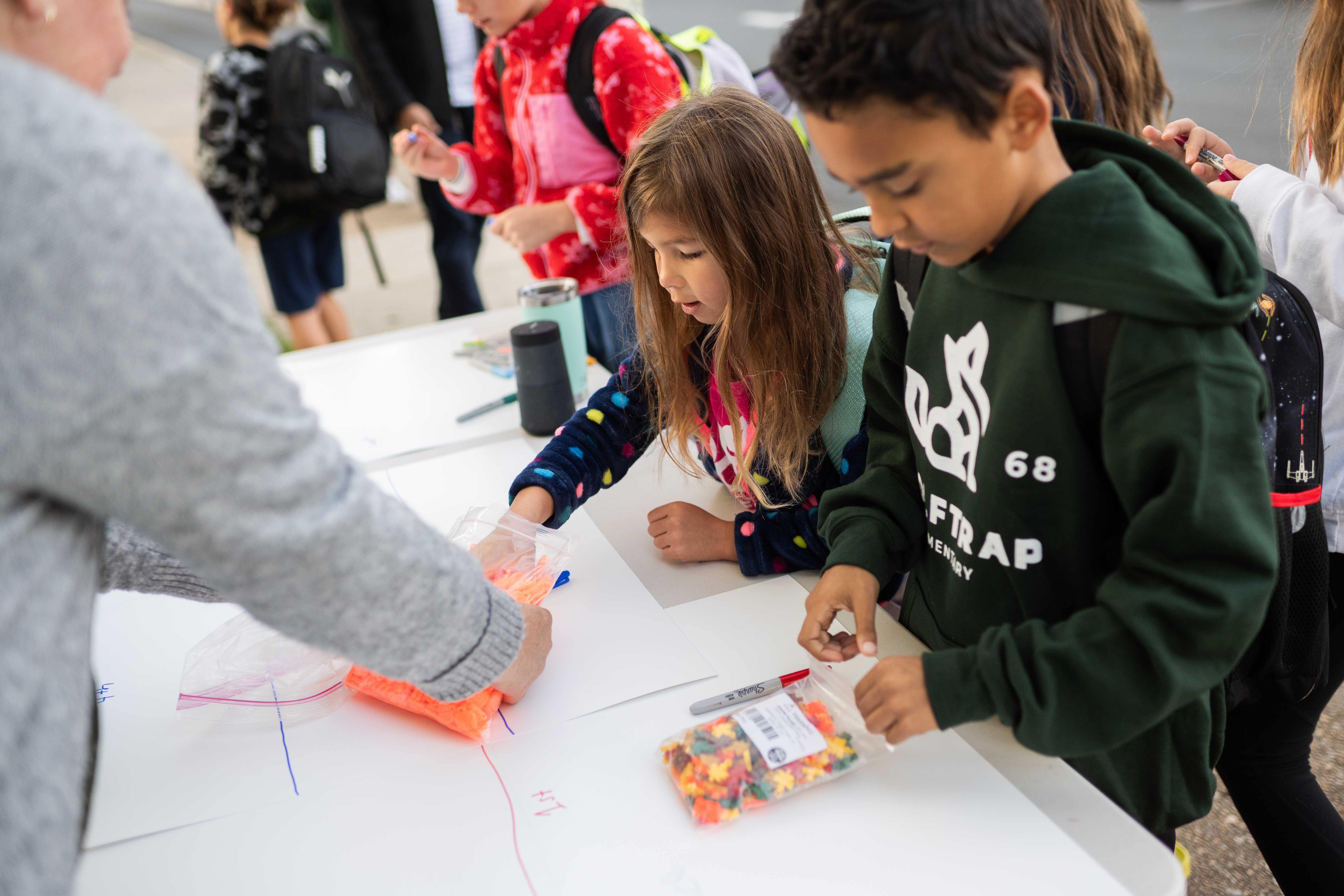 Students sign their names to show they walked to school and collect a charm as a reward.