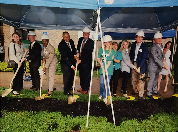 Photograph of the groundbreaking ceremony. Fairfax County School Board members, then Fairfax County Public Schools Superintendent Jack Dale, Chris Shumway, Peter Leyton, then Wolftrap principal Anita Blain, and a Wolftrap student hold gold-painted shovels. Shumway has scooped a shovel-full of earth and is smiling at the camera. 