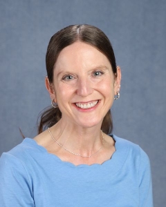 a woman with long dark hair in a blue shirt