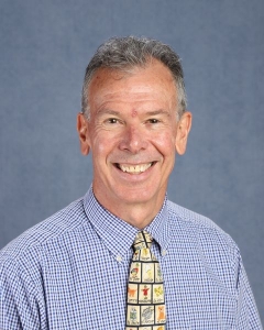 a man with graying hair and blue shirt