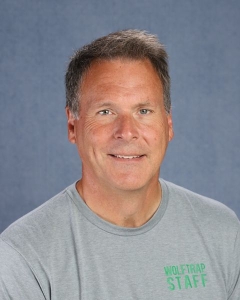 a man with short brown hair and a gray shirt