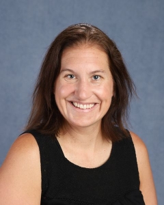 A woman with long dark hair and a dark tank top