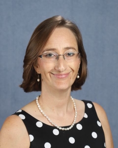 A woman with glasses and a polka dot top