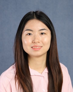 A woman with long dark hair and pink shirt