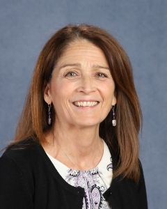 A woman with long dark hair and dark cardigan