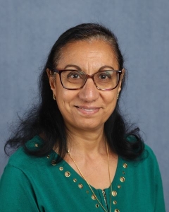 A woman with dark hair and green shirt