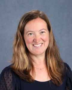 A woman with long blonde hair and dark shirt