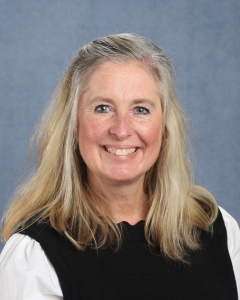 A woman with long blonde hair and black shirt