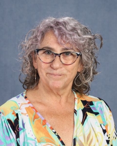 A woman with curly gray hair and glasses