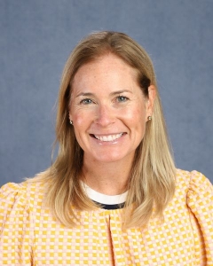 A woman with long blonde hair and yellow shirt