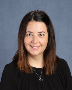 A woman with long dark hair and dark shirt