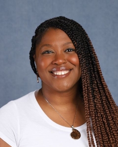 A woman with long brown braids and white shirt