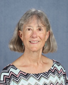 A woman with short gray hair and patterned shirt