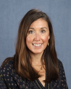 A woman with long brown hair and black shirt