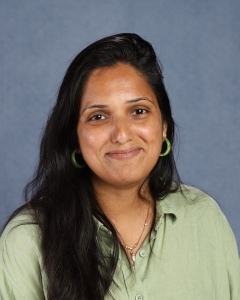 A woman with long dark hair and green shirt