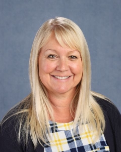 A woman with light blonde hair and black cardigan